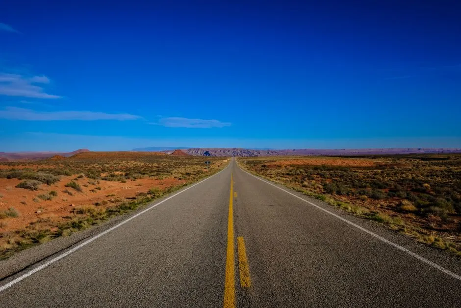 Long desert highway stretching toward distant mesas