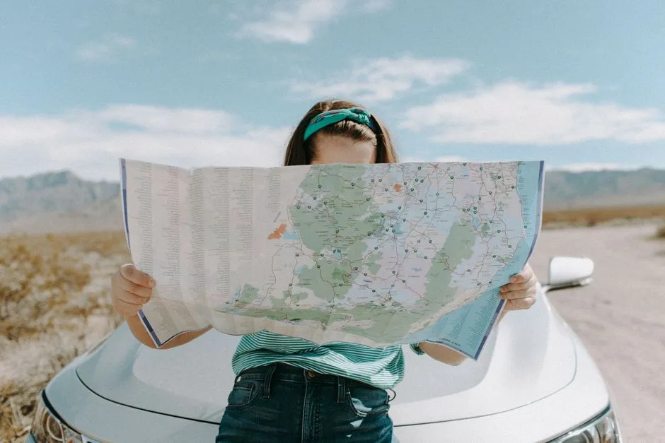Traveler reviewing a paper map while planning a road trip itinerary